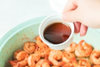 sauce poured over spicy mexican shrimp in a blue bowl.
