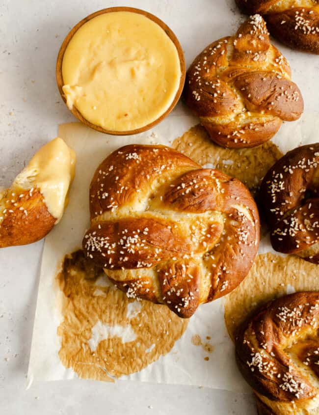 overhead view of homemade pretzels next to a cup of cheese sauce.