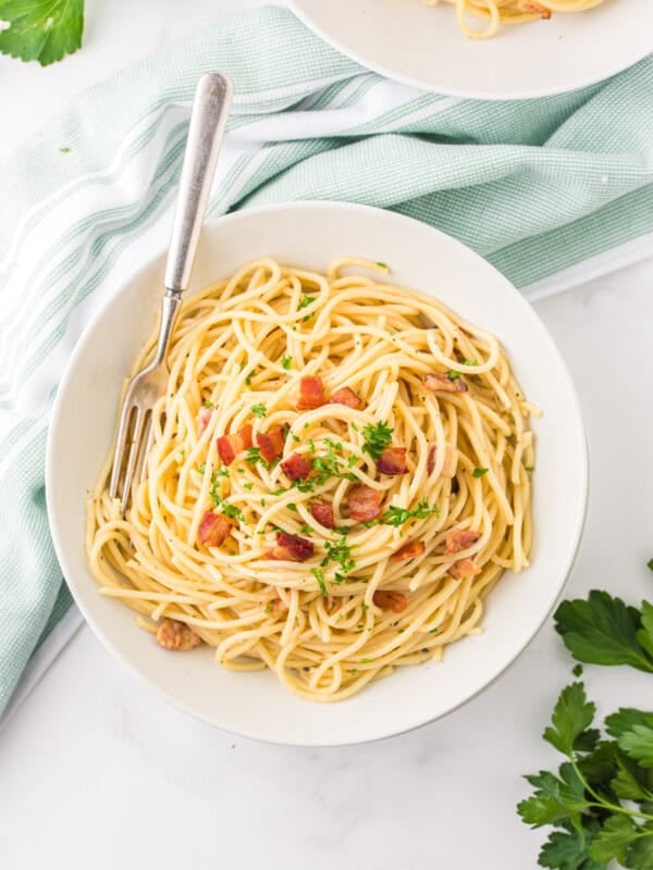 overhead view of spaghetti carbonara in a white bowl.