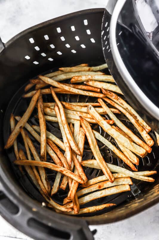 cooked air fryer french fries in an air fryer basket.