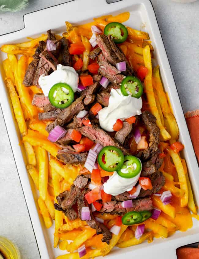 overhead view of carne asada fries on a white tray.
