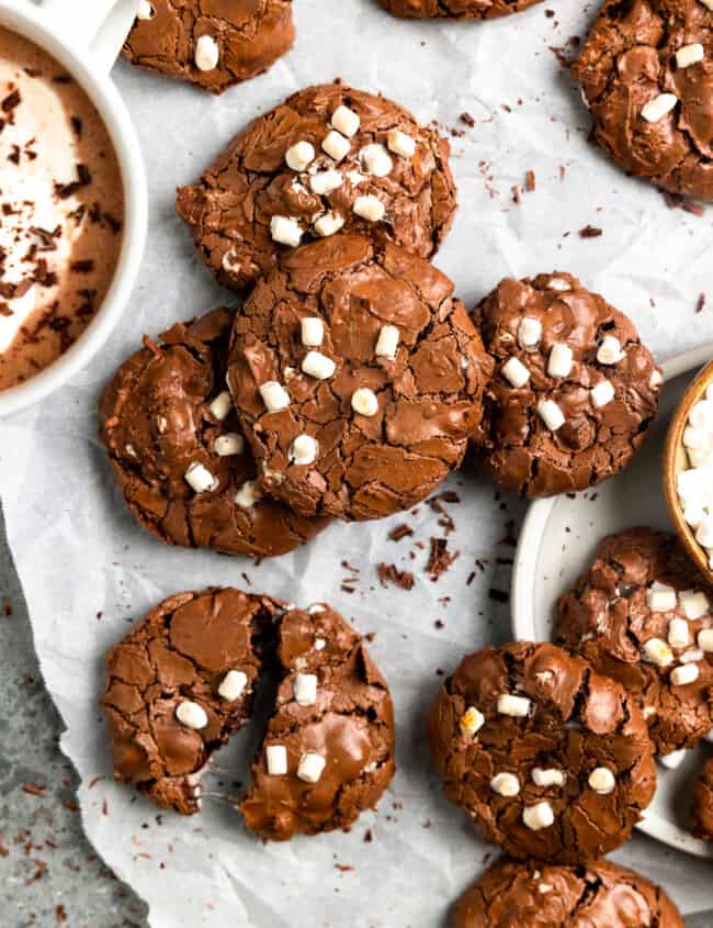 overhead view of flourless hot chocolate cookies arranged on crinkled parchment paper.