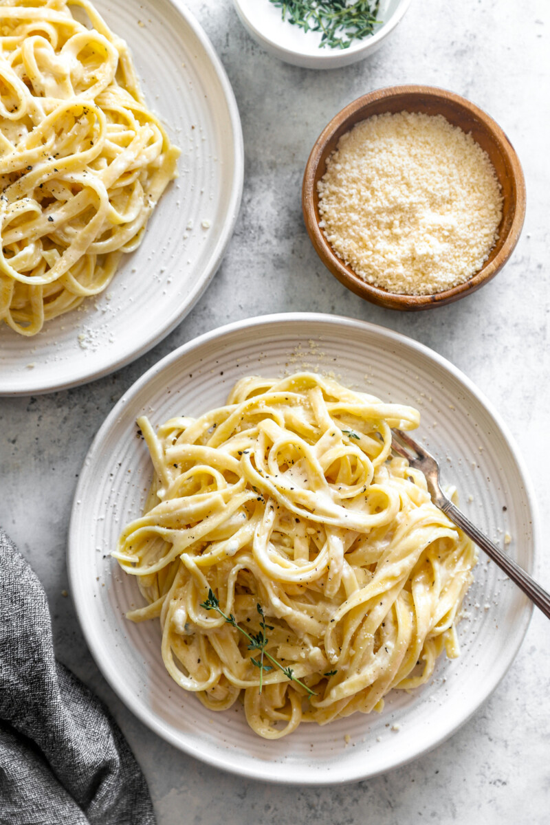 overhead view of a serving of fettuccini alfredo on a white plate with a fork.