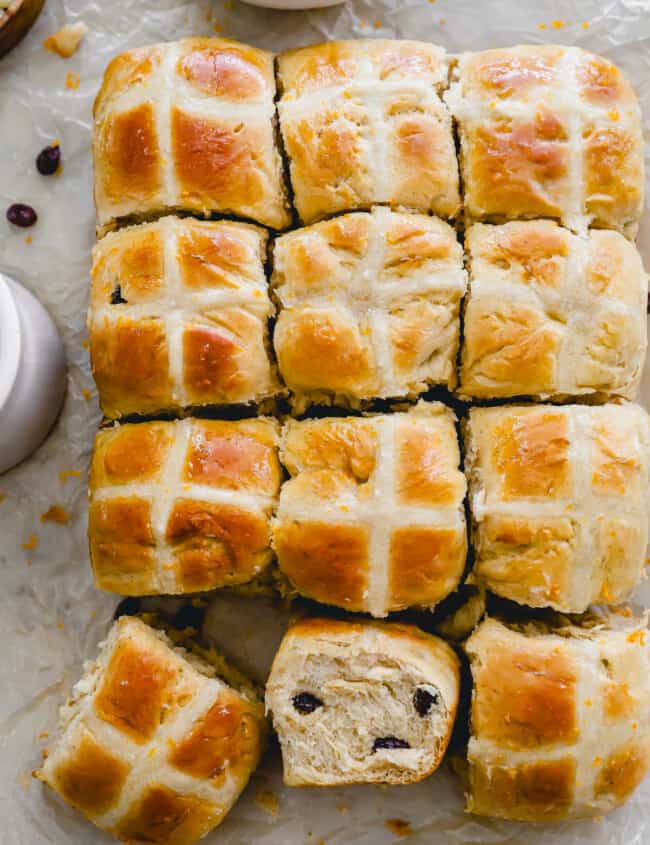 overhead view of hot cross buns, one turned on its side to show the texture.