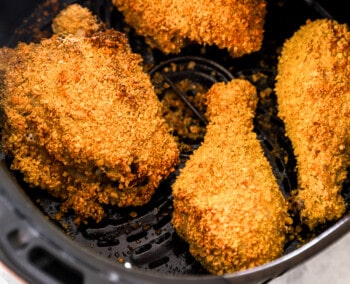 overhead view of air fryer fried chicken in an air fryer basket.