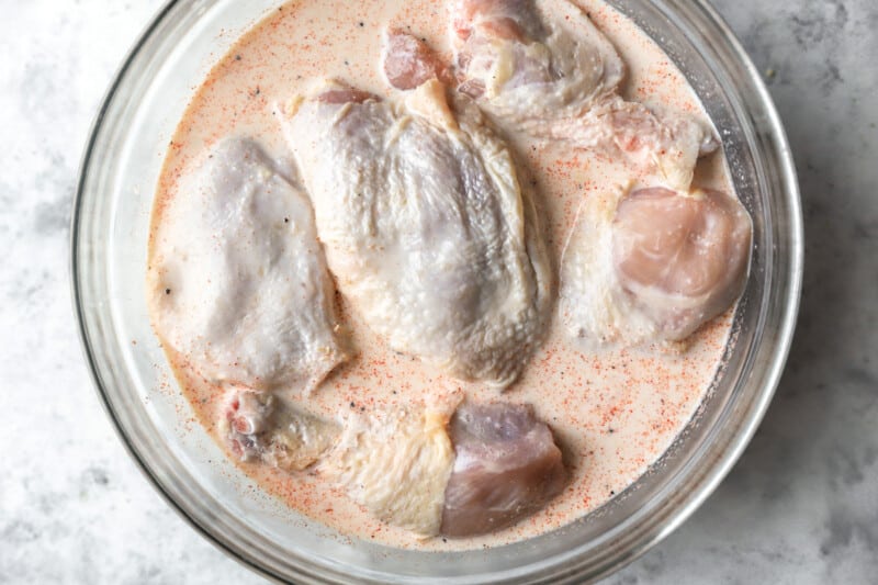 marinated raw chicken in a glass bowl.