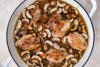 chicken thighs nestled into a pot filled with rice and veggies.