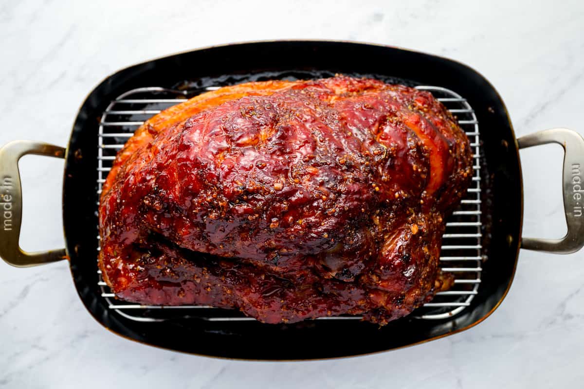 a roasted ham in a roasting pan.