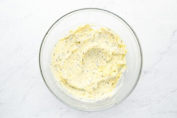 lemon butter in a glass bowl on a marble countertop.