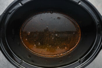 apple cider, brown sugar, and spices whisked together in a crockpot.