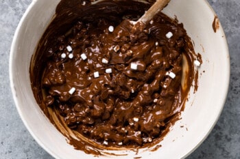flourless hot chocolate cookie batter in a white bowl with a wooden spoon.