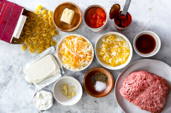 overhead view of ingredients for hamburger casserole in individual bowls.