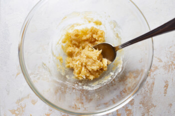 flour, parmesan, and butter paste in a glass bowl with a spoon.