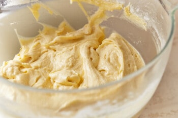 dry ingredients added to italian cream cake batter in a glass bowl.