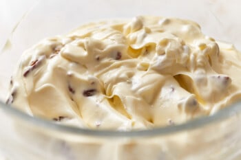 Italian cream cake frosting with pecans in a glass mixing bowl.