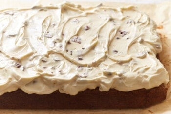 frosted Italian cream cake on a cutting board.