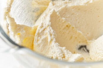 sugar added to whipped butter and shortening in a glass mixing bowl.