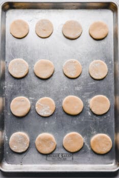 16 baked lofthouse sugar cookies on a baking sheet.