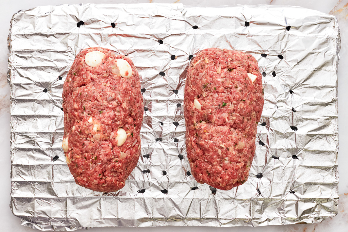 2 mozzarella stuffed meatloaves on a wire rack. - 10