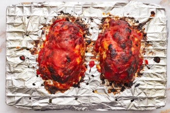 2 broiled mozzarella stuffed meatloaves on a wire rack.