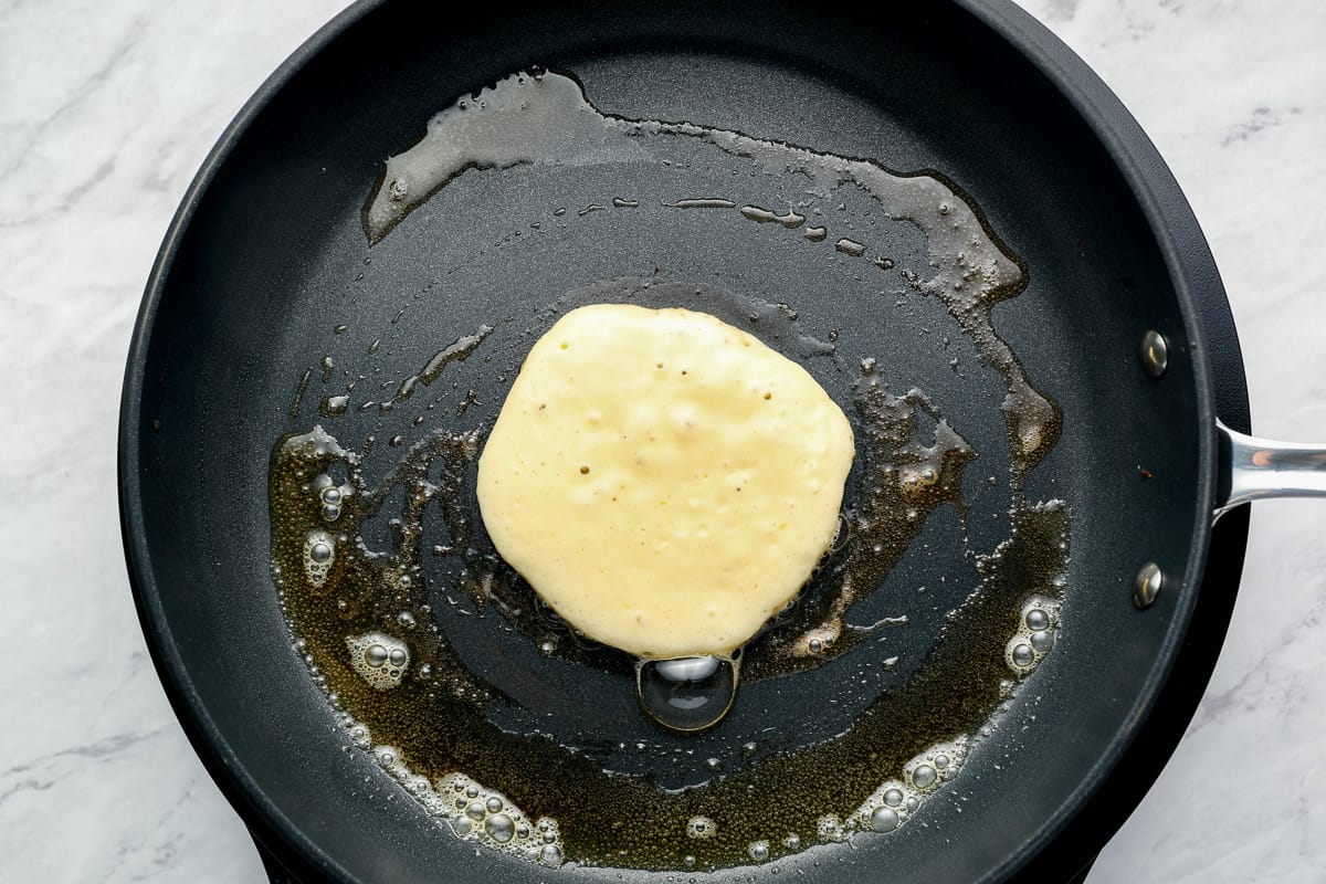 pancake batter in a buttered cast iron pan.