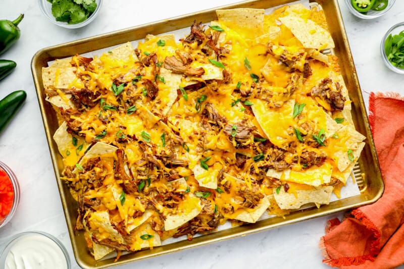 baked pulled pork nachos on a baking sheet.