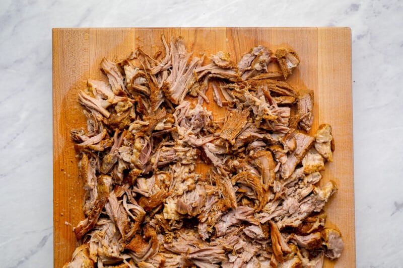 shredded pork carnitas on a cutting board.