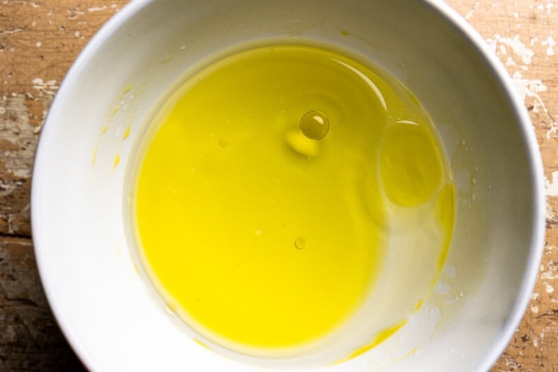 wet ingredients for no knead focaccia in a white bowl.