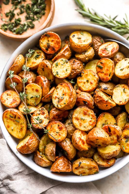 overhead view of roasted potatoes in a white bowl.