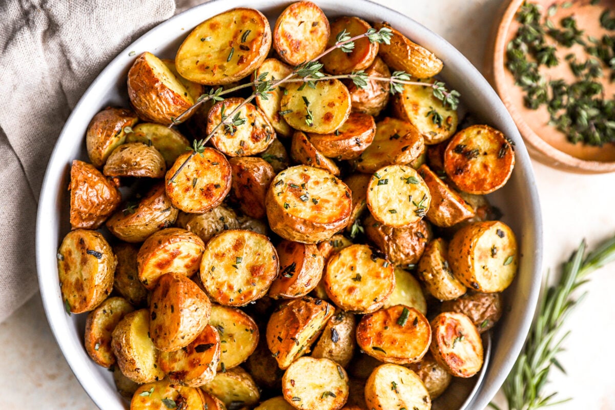 overhead view of roasted potatoes in a white bowl.