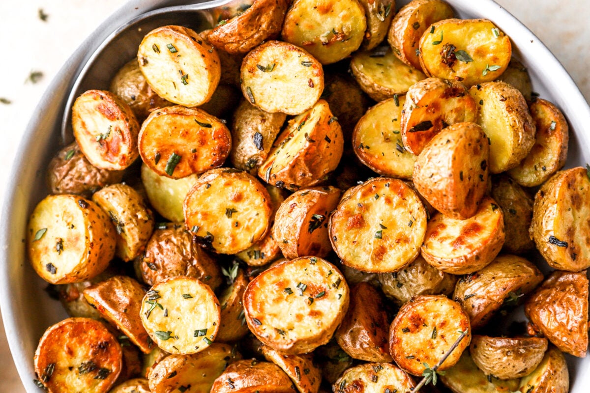 partial overhead view of roasted potatoes in a white bowl.