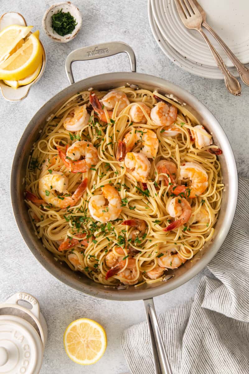 Overhead view of shrimp scampi in a frying pan garnished with parsley.