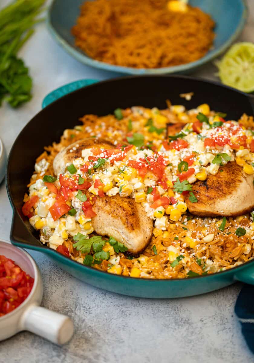 three-quarters view of Mexican street corn chicken in a cast iron skillet.
