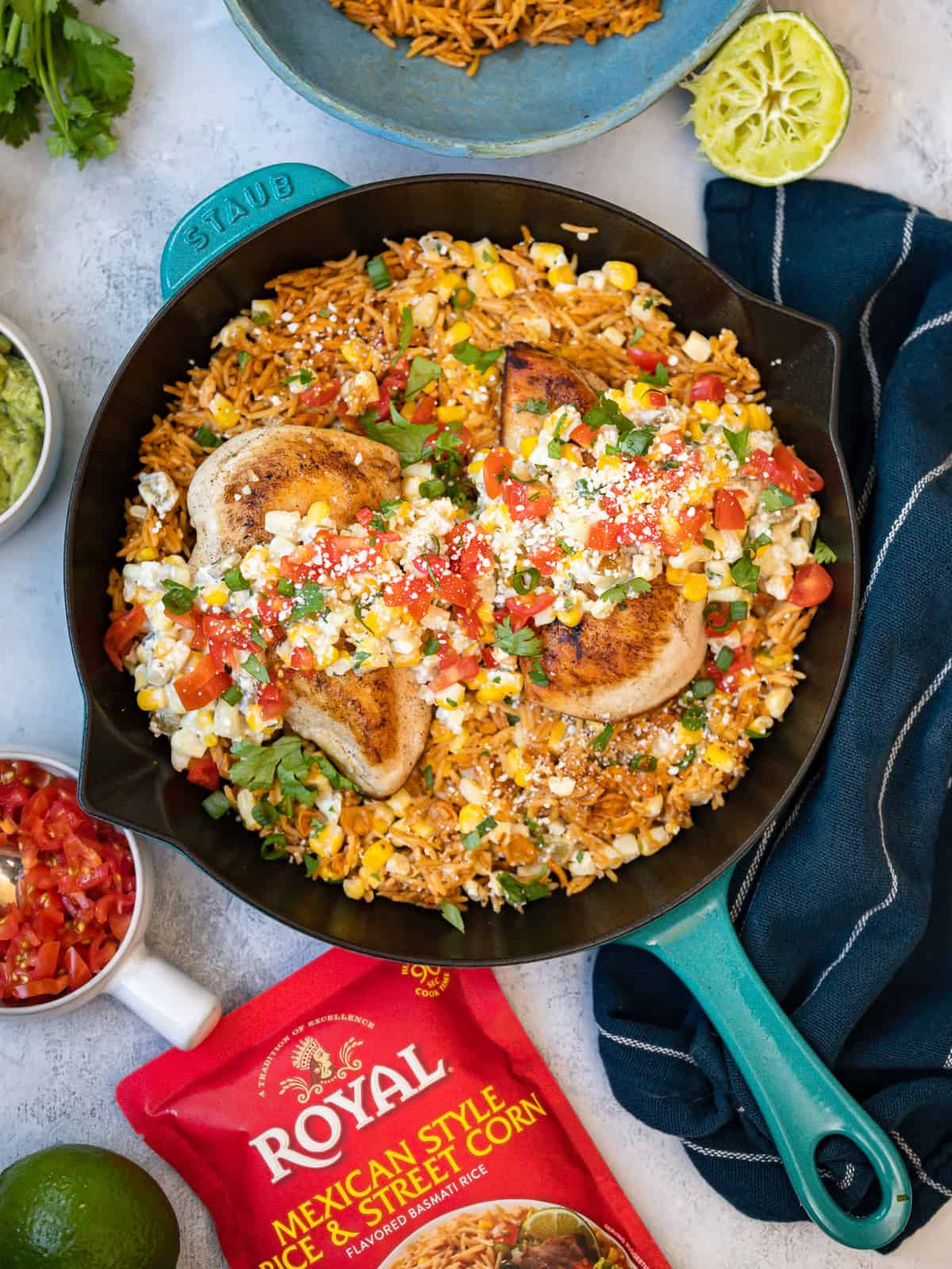 overhead view of Mexican street corn chicken in a blue cast iron skillet next to a bag of Royal rice.