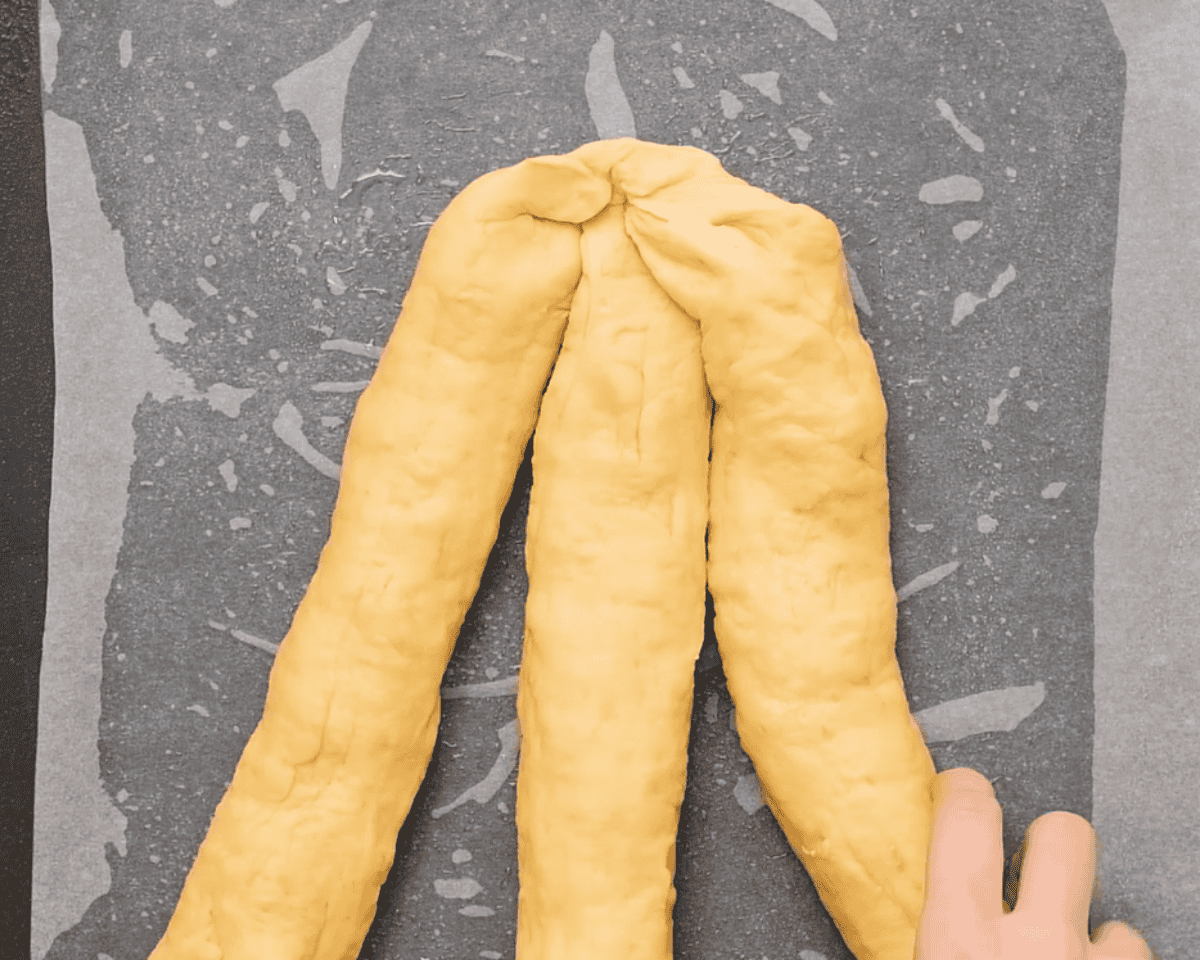 3 strips of dough to be braided on a parchment lined cookie sheet.