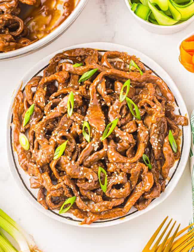 a plate of korean beef on a white table.