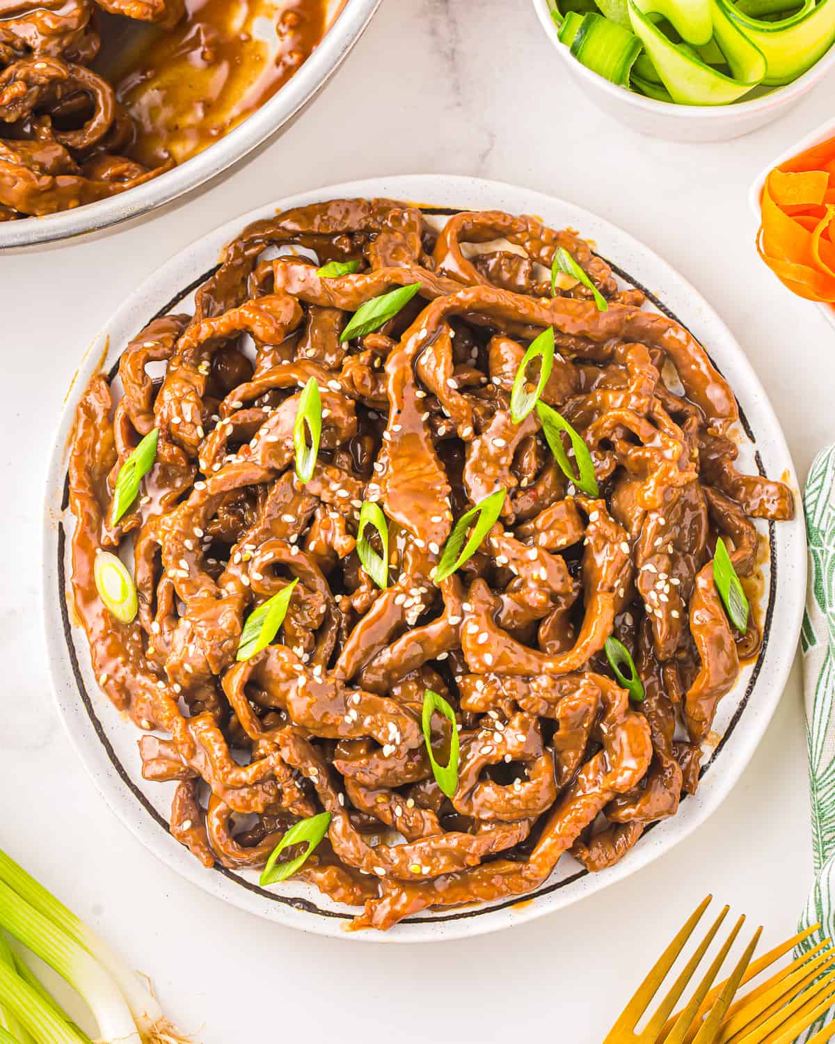 a plate of korean bulgogi beef on a white table.