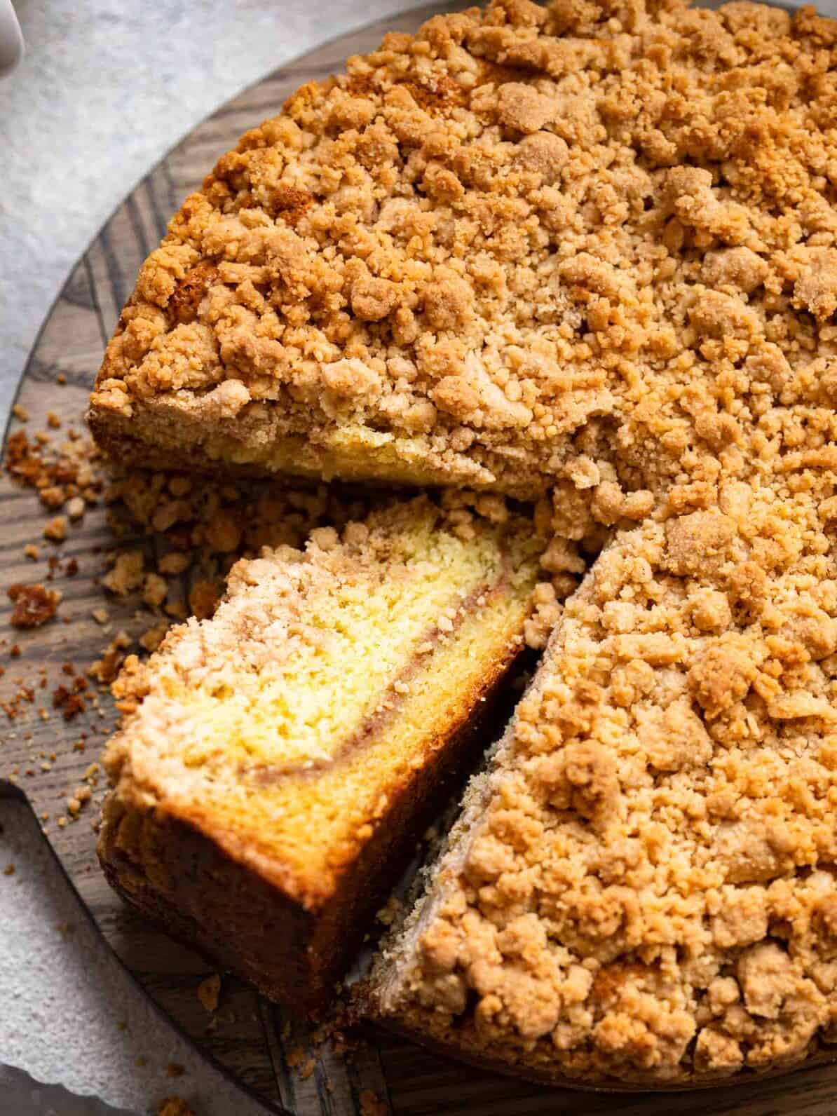 three-quarters view of cake mix coffee cake on a cake plate with one slice cut out and turned up to show the streusel layer.