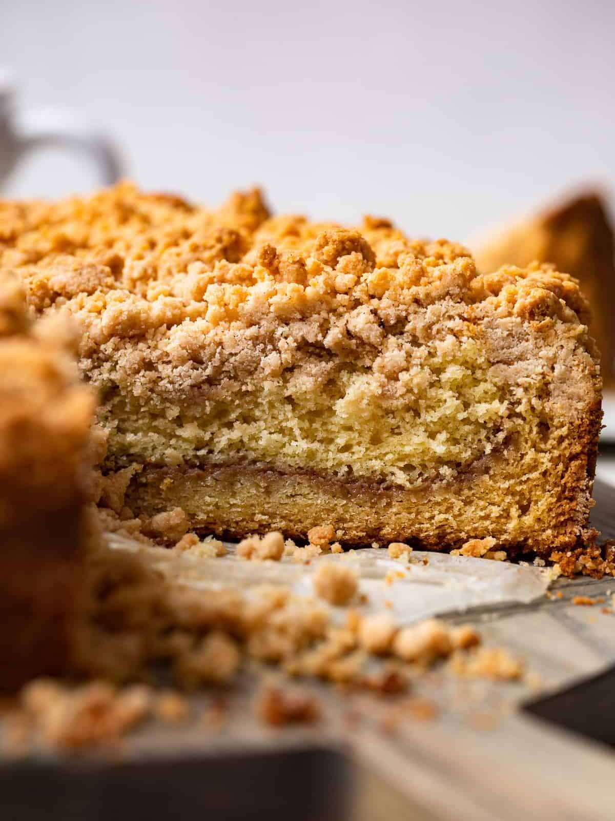 side view of a cut cake mix coffee cake on a cake plate with a slice missing.