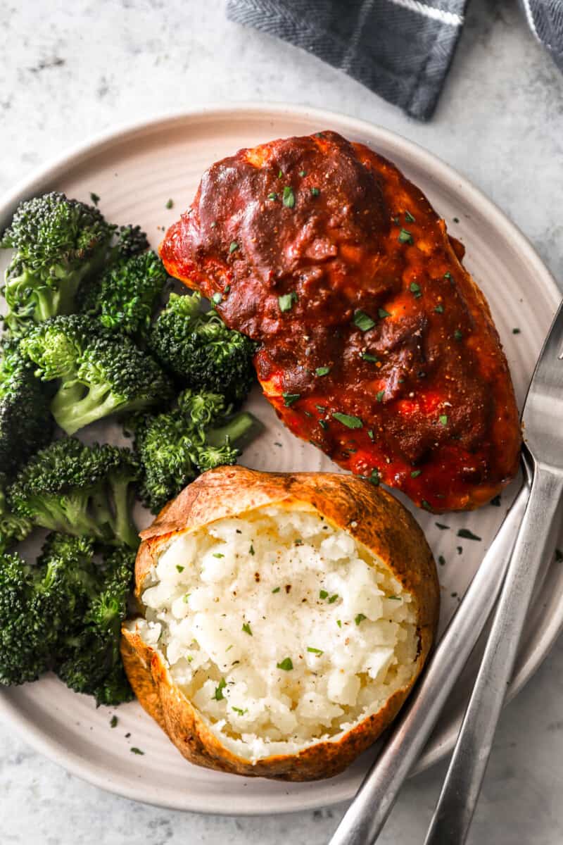 slow cooker barbecue chicken on a plate with broccoli and a baked potato