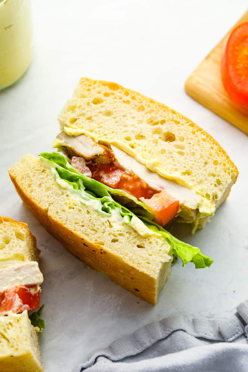 overhead view of a sandwich on ciabatta bread with mayonnaise facing up to show the layers.