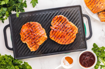 overhead view of 2 grilled pork chops on a rectangular grill pan.