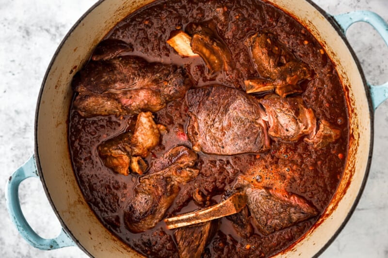 cooked birria taco meat in a blue and white dutch oven.