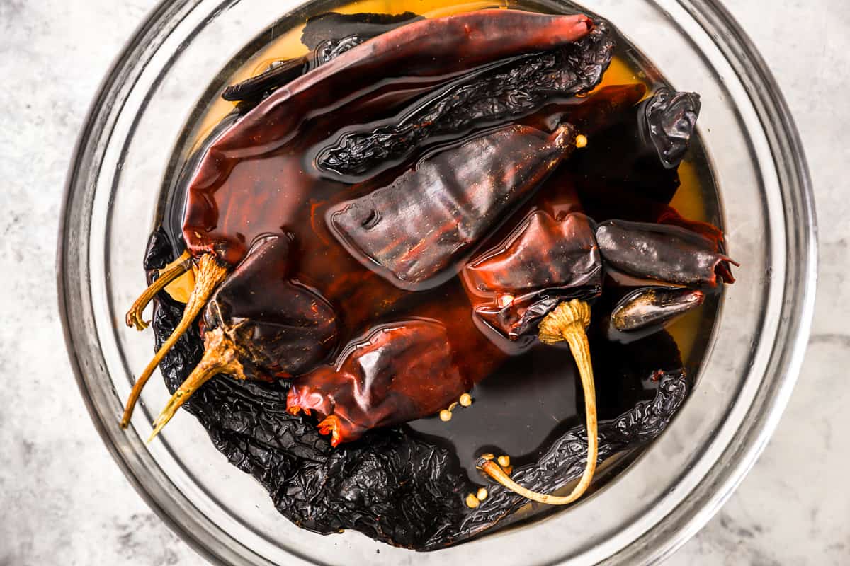 chiles in water in a glass bowl.