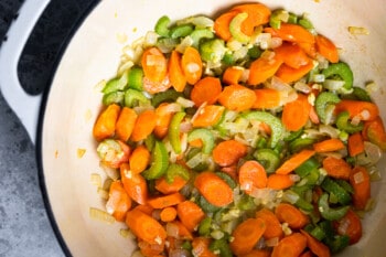 overhead view of sauteed veggies in a dutch oven.