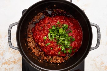 a pot full of chili in a black pan.