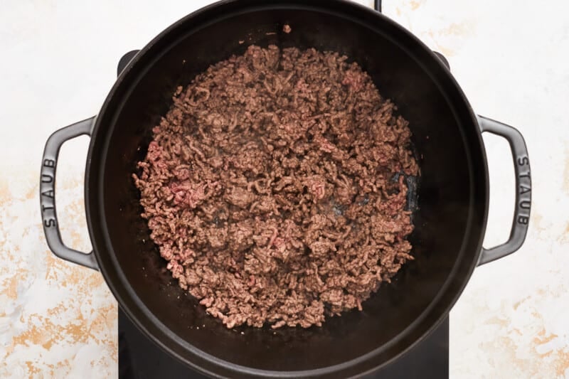 the ground beef is being cooked in a skillet.