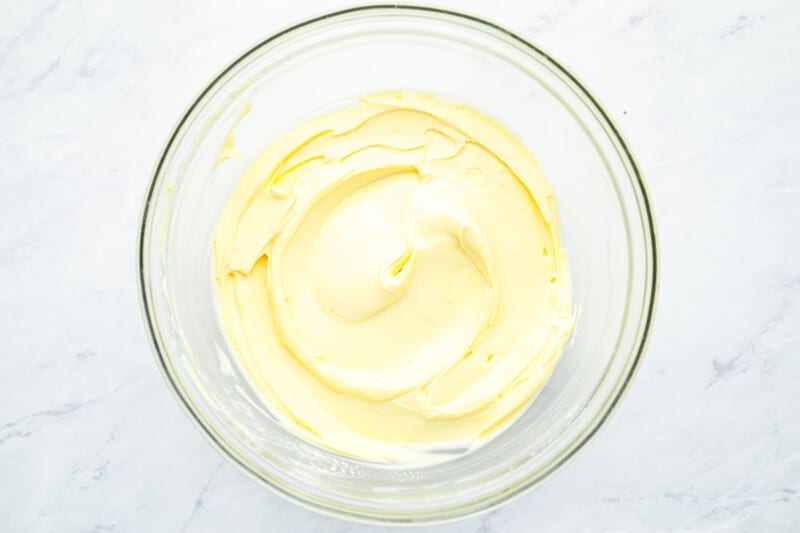 lemon juice and salt added to mayonnaise in a glass bowl.