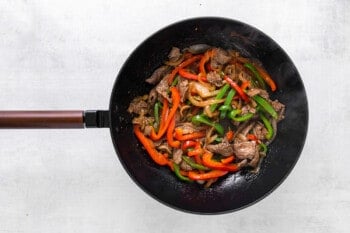 a wok full of stir fried vegetables and meat.