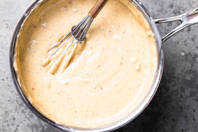 a pan of sauce with a whisk in it.